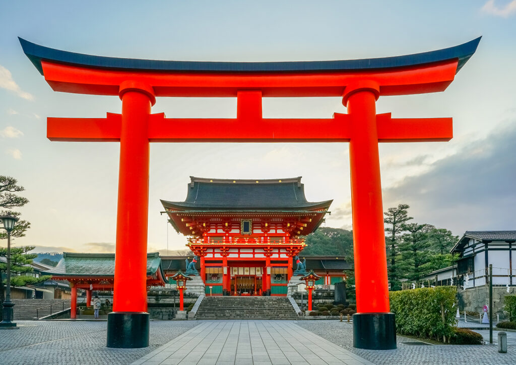 Fushimi Inari Shrine at sunrise, Kyoto, Japan. The japanese on the building means Fushimi Inari Shrine.